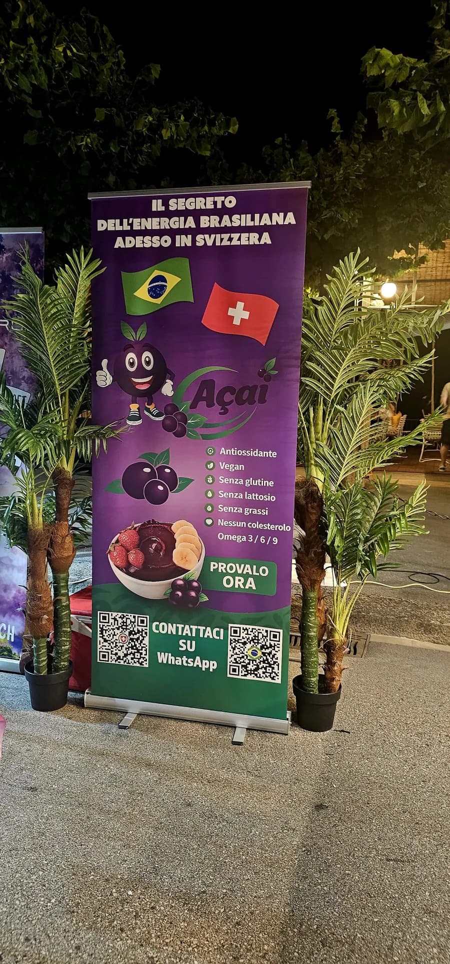 Il banner Fruit's Açaí tra le palme a un evento serale